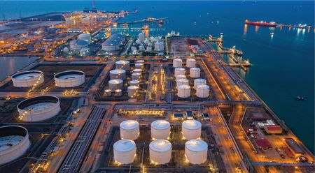 Refinery on the coast with storage tanks in low light