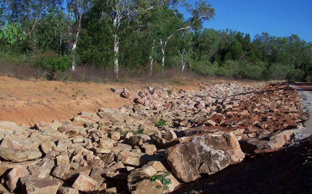 A Pile Of Rocks In A Field With Trees In The Background — Coleman's Contracting & Earthmoving In Humpty Doo, NT