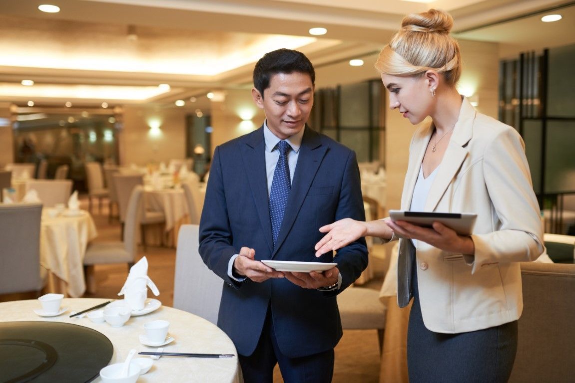 Event planner in business attire discussing with a corporate representative in suit and tie