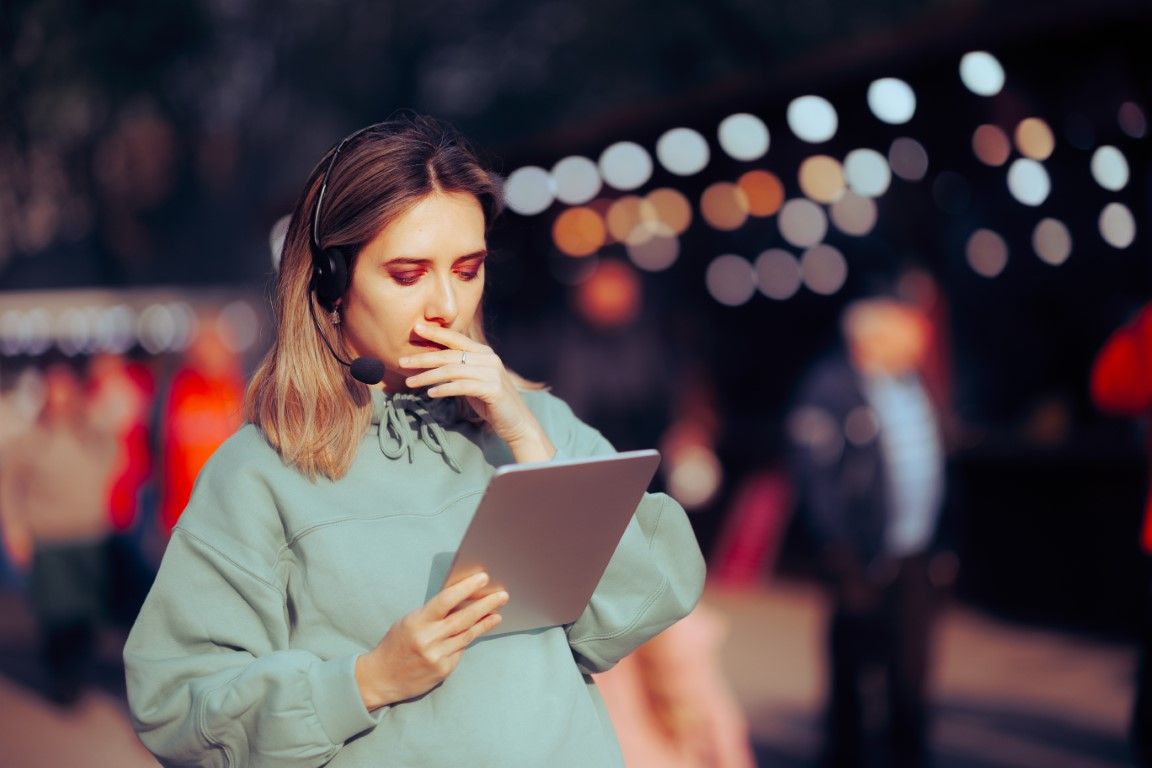 Event planner with a tablet and headphone in a corporate gala