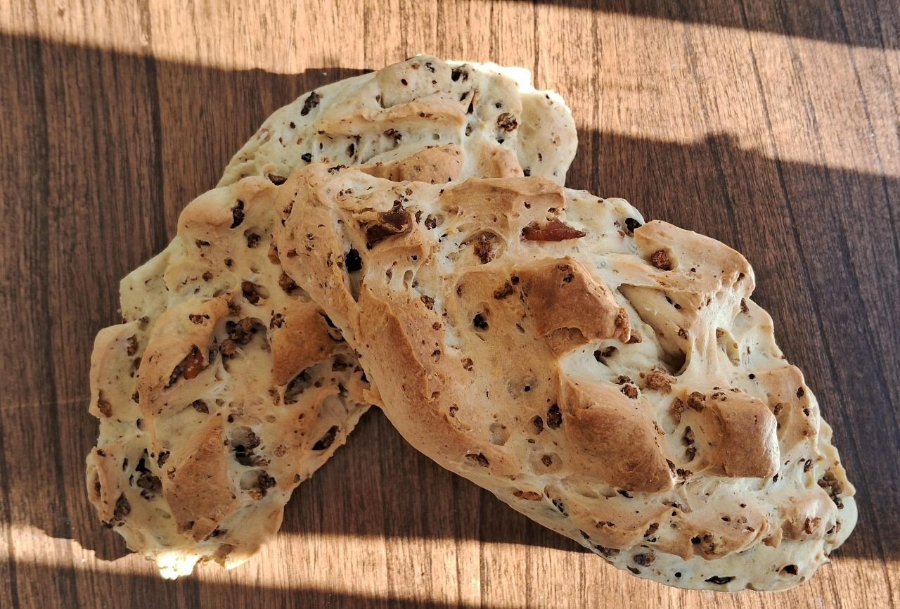Dos rebanadas de pan están apiladas una encima de otra sobre una mesa de madera.