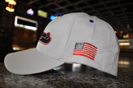 A white baseball cap with a partial logo visible on the front and an embroidered American flag on the side.