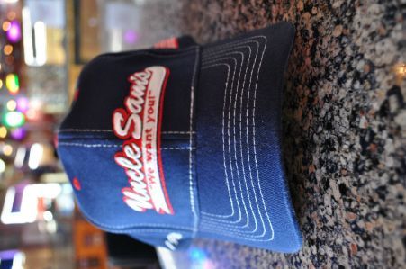 A dark blue baseball cap with the white and red embroidered text 