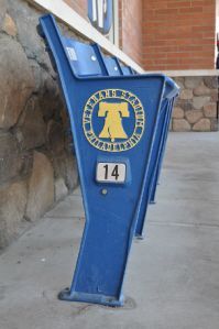 Blue stadium seats from Veterans Stadium Philadelphia, marked with the Liberty Bell logo and seat number 14.