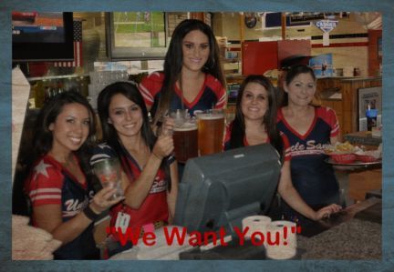 Four smiling staff members in team jerseys at a bar, holding drinks and a food tray, with the text 