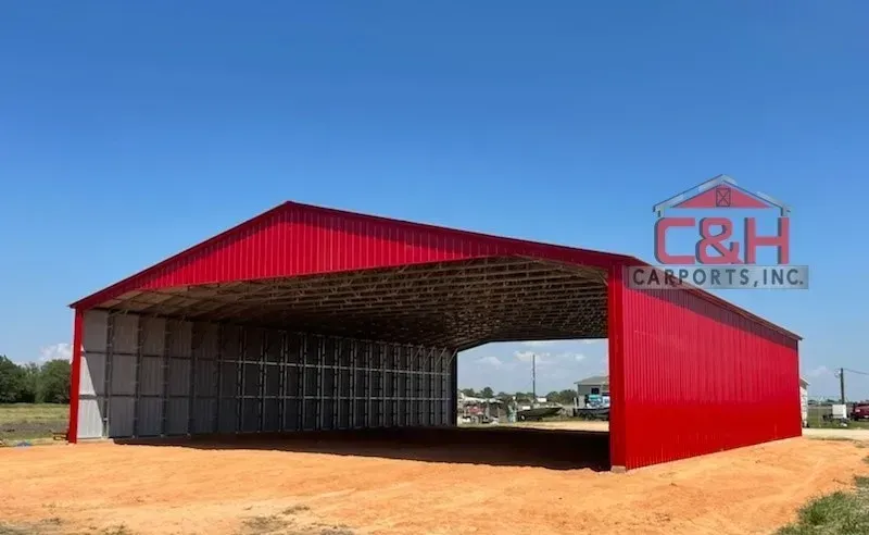 large red metal building used as a hanger for a plane