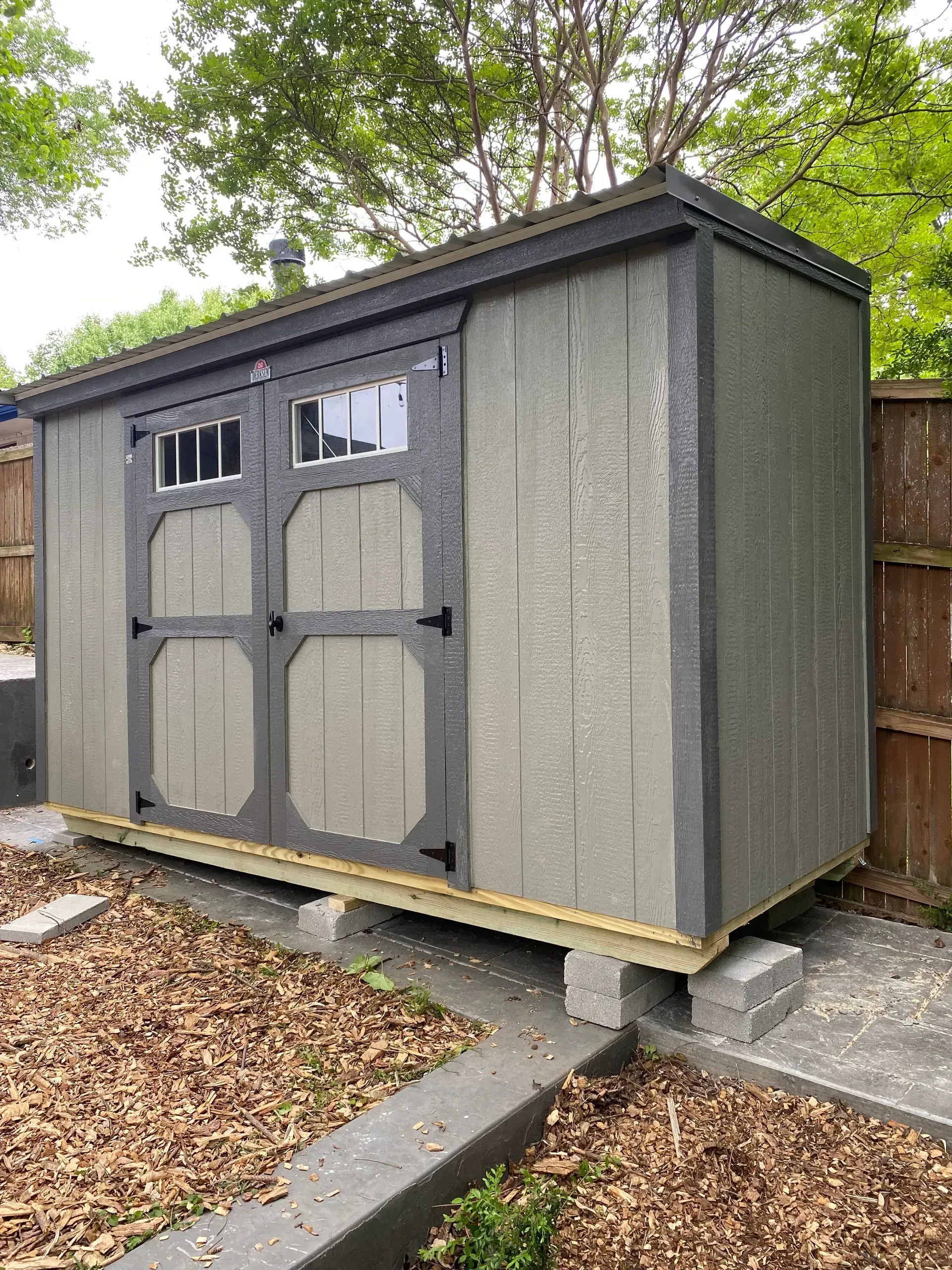 small gray shed with double doors