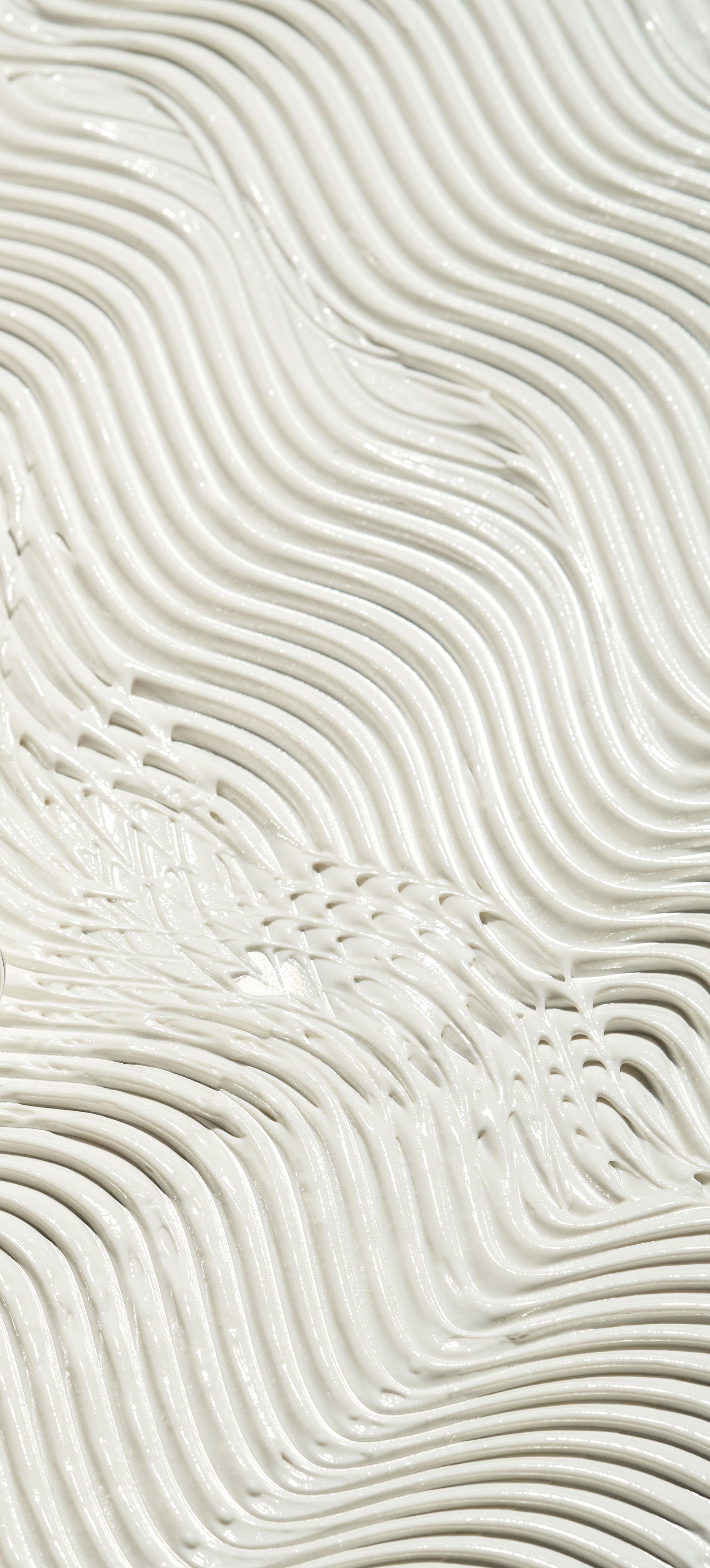 Abstract, wavy, white texture. Lines and shadows create a flowing, rippled effect.
