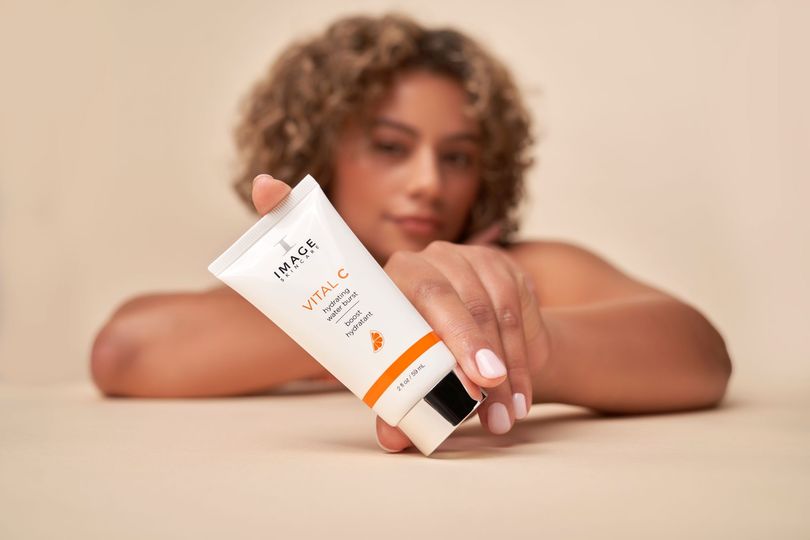 Woman holding a white tube of 