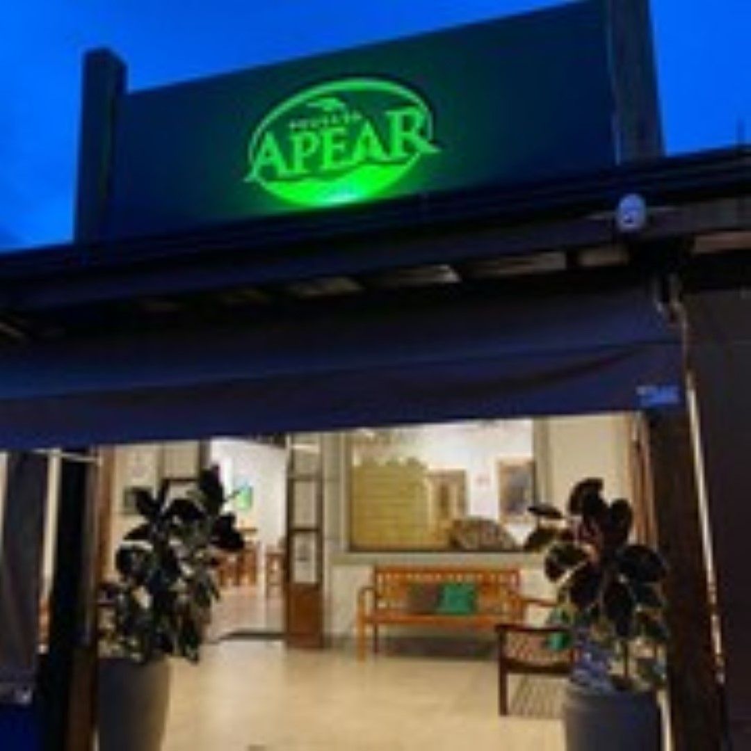 Entrada do restaurante com placa verde iluminada