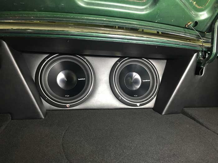 black and silver speakers in a green car trunk