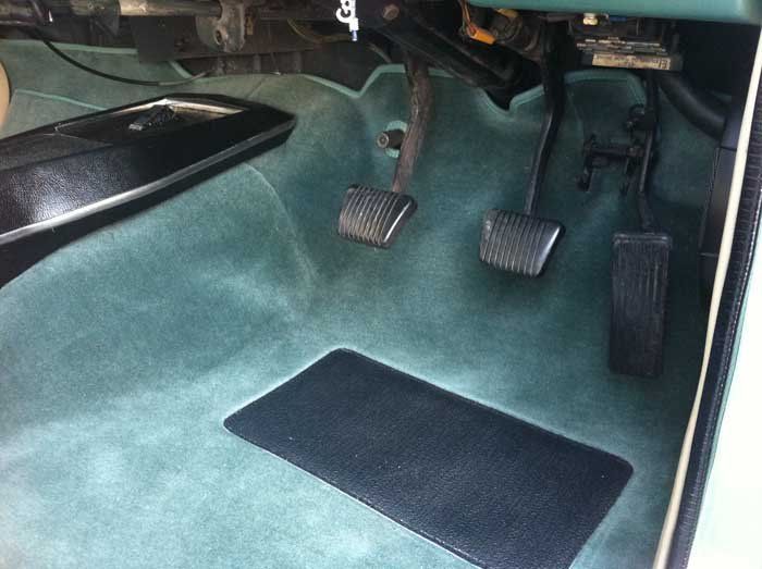 green carpet and a gas pedal and brake pedal