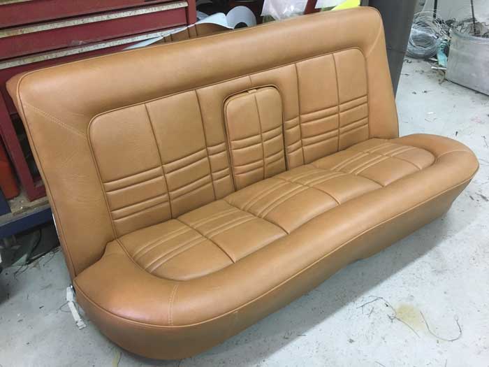 brown car seat with arm rest folded inside