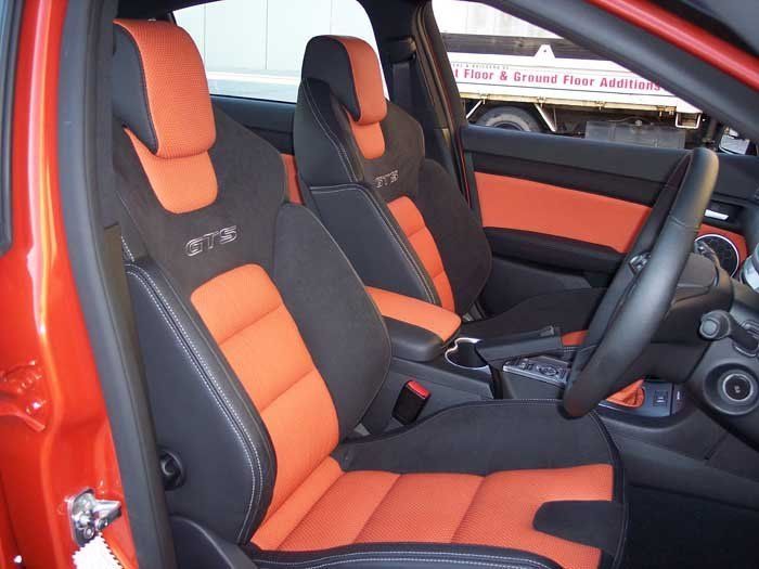 two front seats with a black steering wheel
