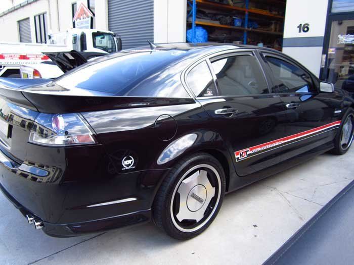 a black car with a small red and white stripe