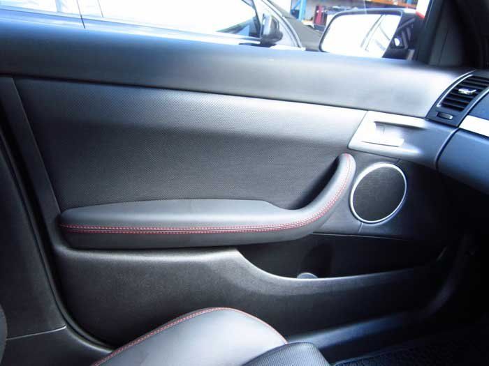 a grey car door with red stitching