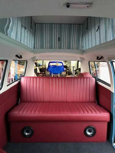new red bench seat with speakers in volkswagen van