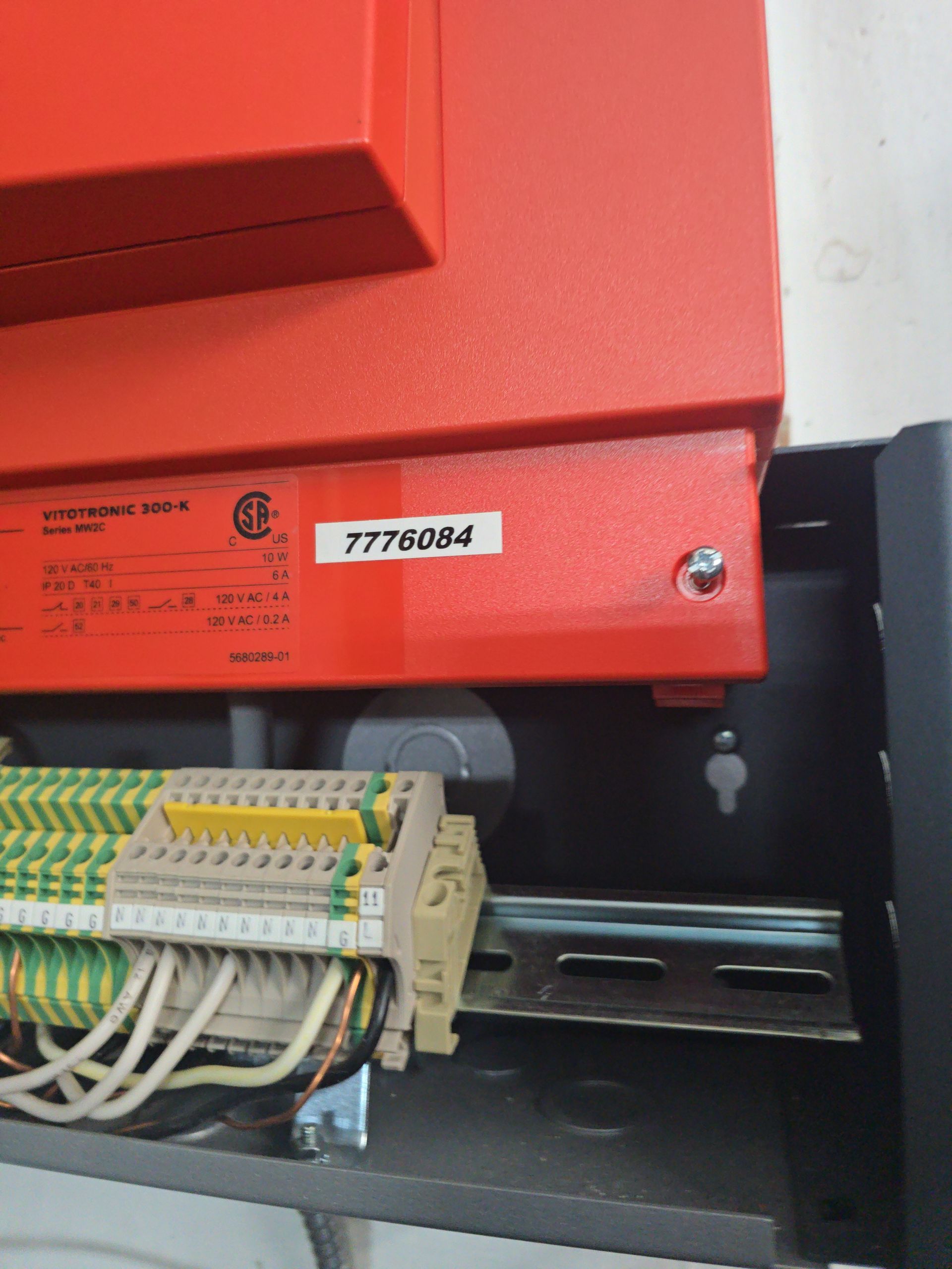 Red electrical panel with wiring, terminal blocks, and a serial number label.