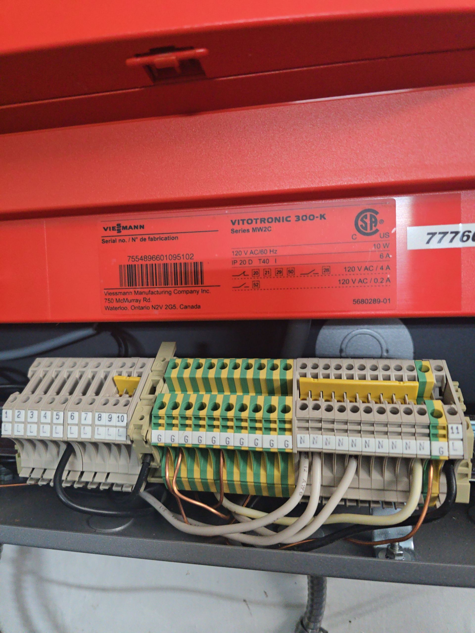 Red electrical component with wiring connected to terminal blocks.