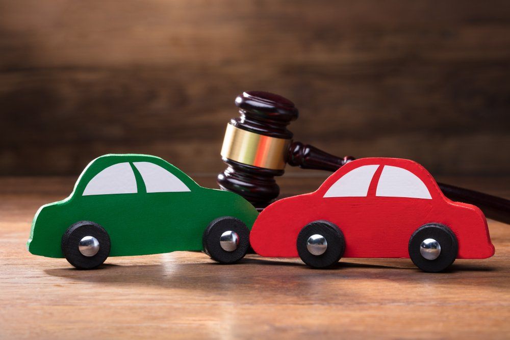 Collision Of Wooden Two Toy Cars In Front Of Gavel On The Wooden Table