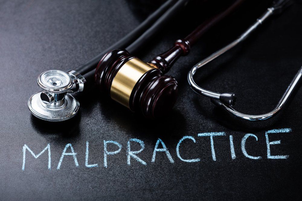 the word malpractice next to gavel and stethoscope 