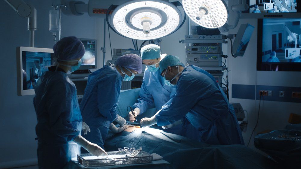 surgical team in operating room performing on a patient
