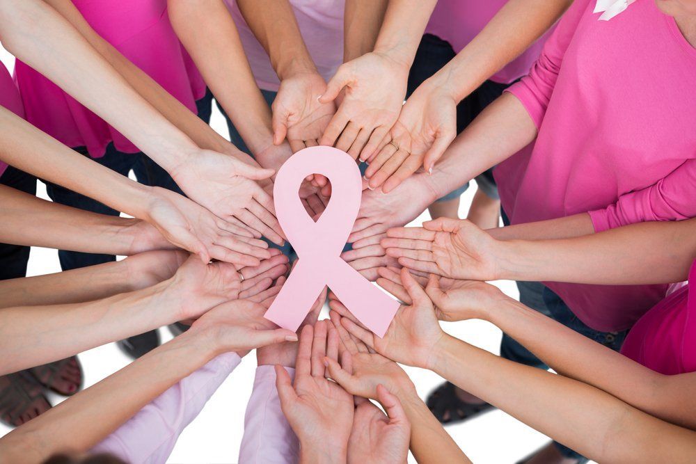 women holding a pink breast cancer awareness ribbon