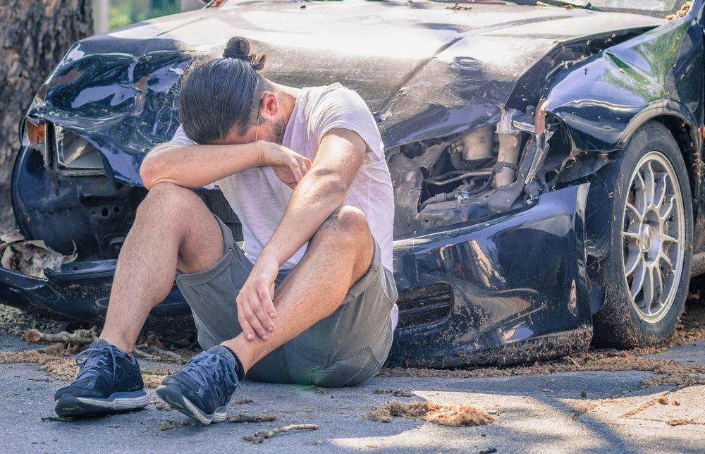 Can you get PTSD from a car accident? Ask this man sitting next to car after accident