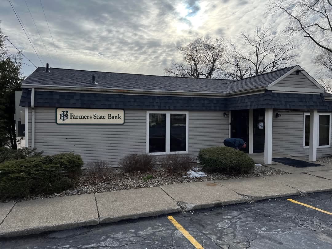 Exterior view of a light gray building with the sign 