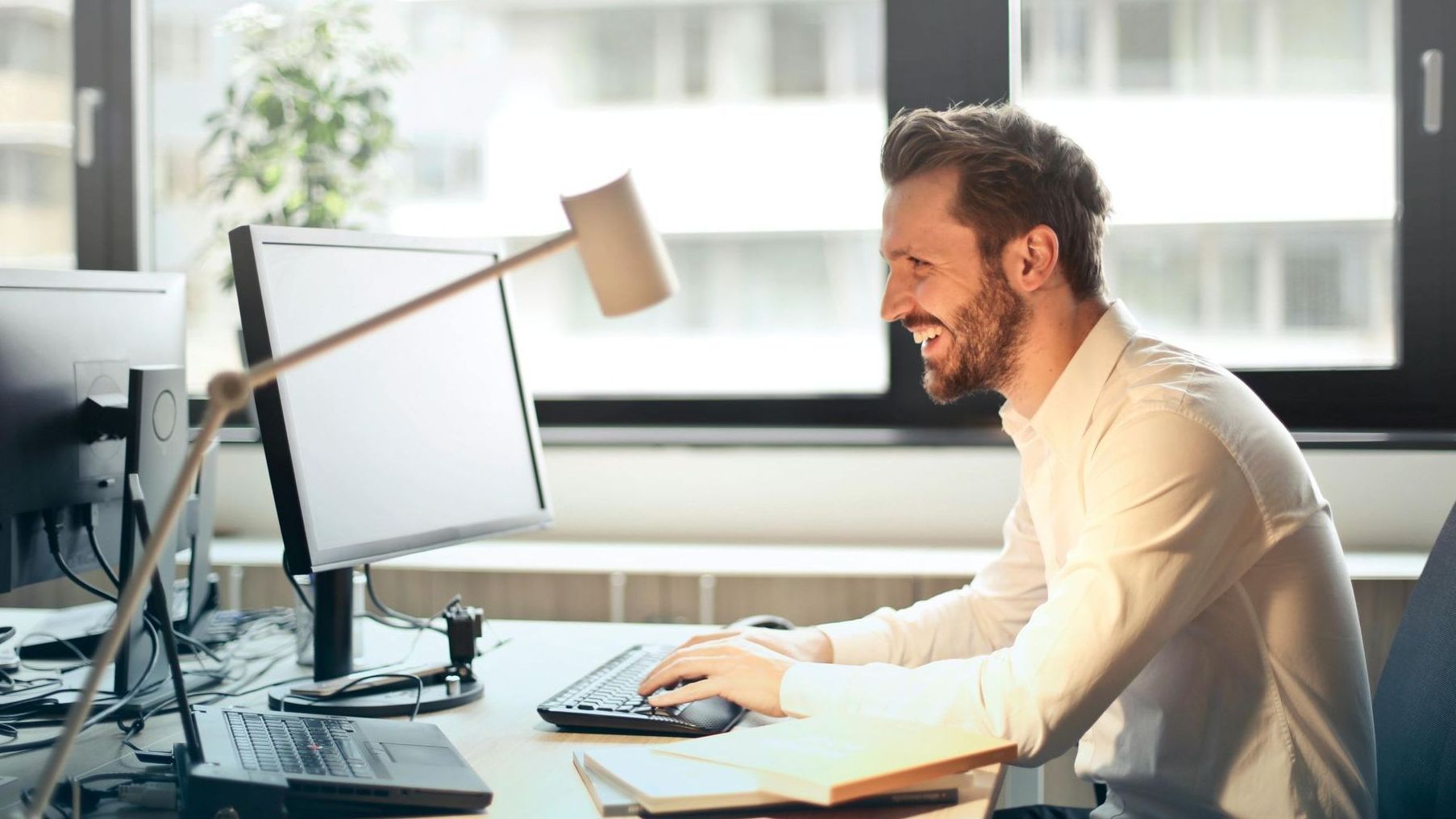 A man is sitting at a desk in front of a computer.
