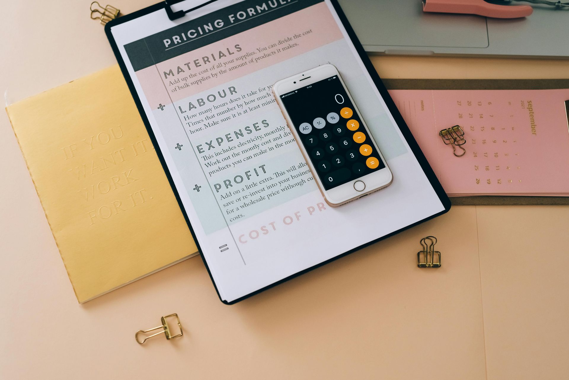 A clipboard with a cell phone and calculator on it.