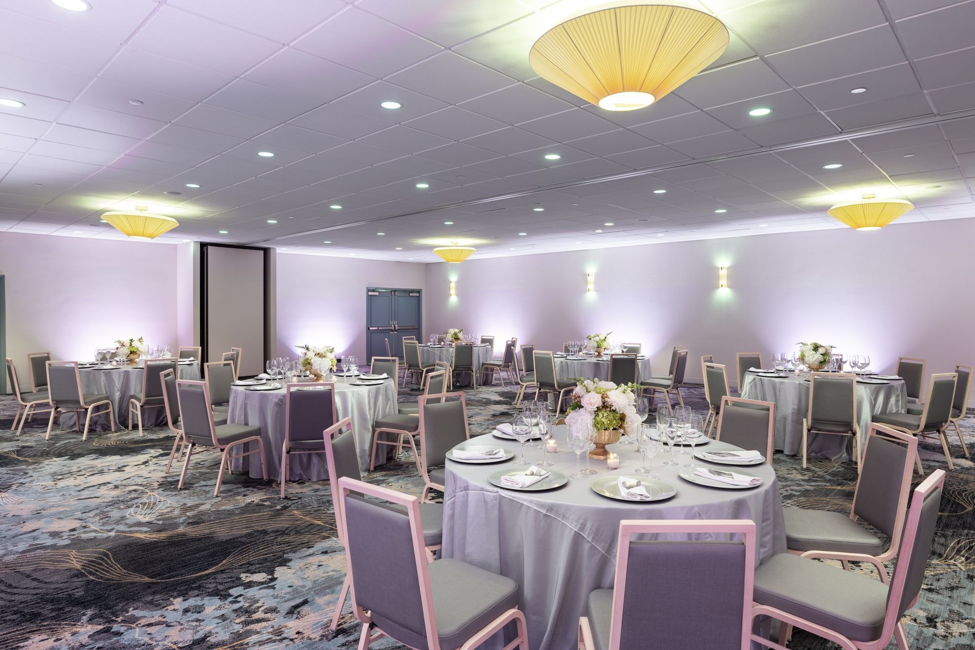 A large banquet room with tables and chairs set up for a wedding reception.