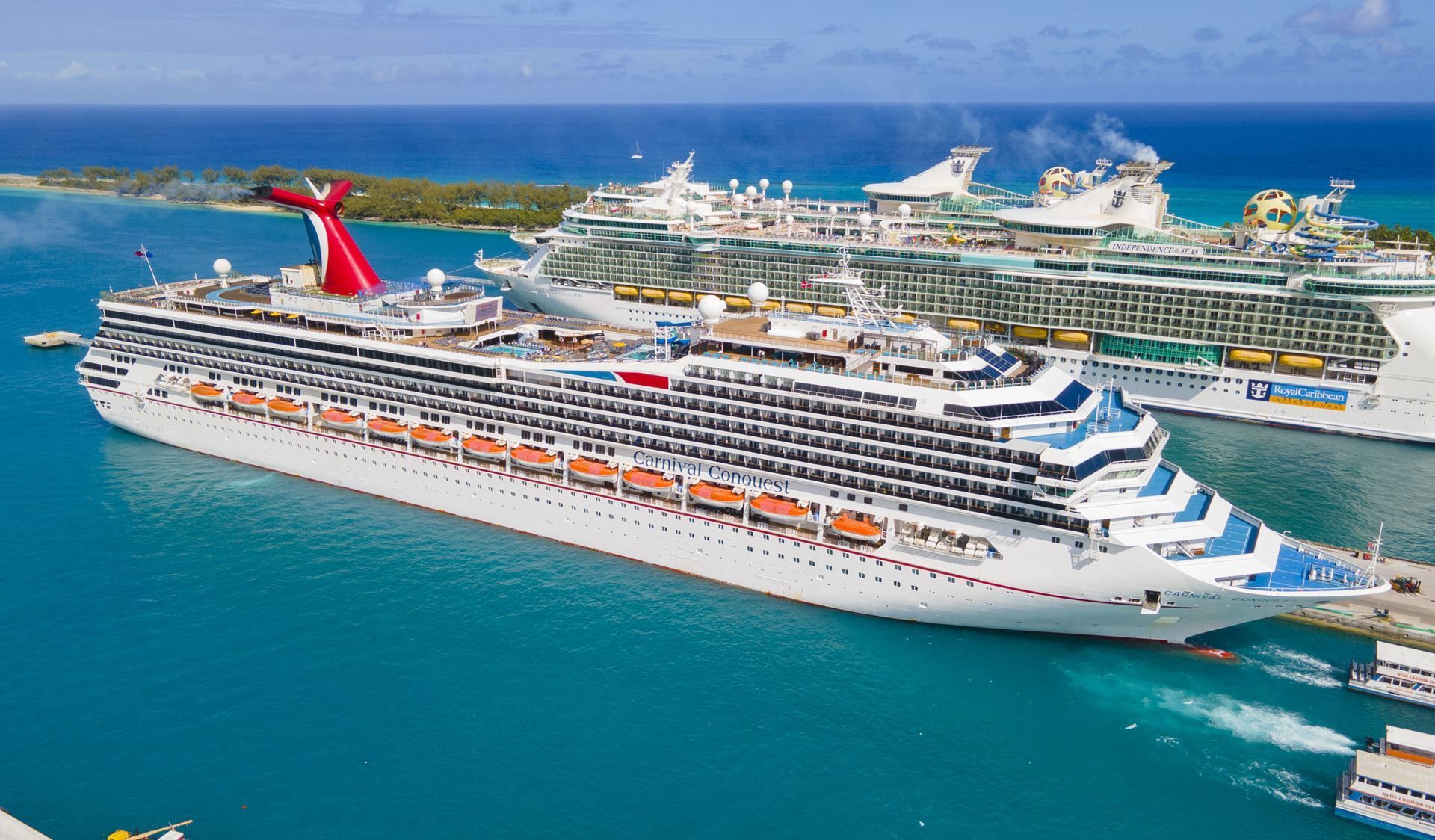 A group of cruise ships are docked in a harbor.