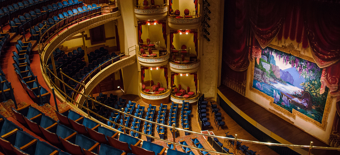 An aerial view of an empty theatre with blue seats and a stage.