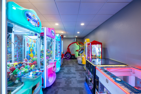 Arcade games and claw machines in a room.
