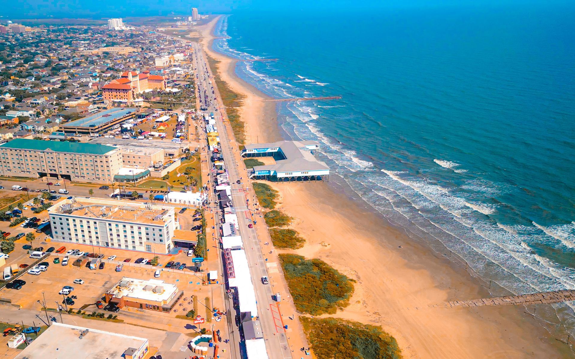 An aerial view of a beach with a city in the background.