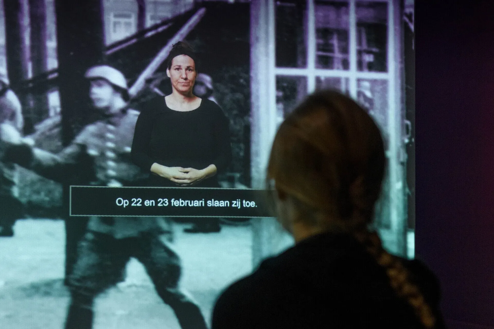 A person from the back, watching a video at the Resistance Museum.