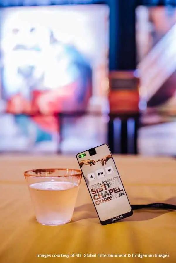 Un Podcatcher Guide-ID appuyé contre un verre d’eau lors de l’exposition sur la chapelle Sixtine.