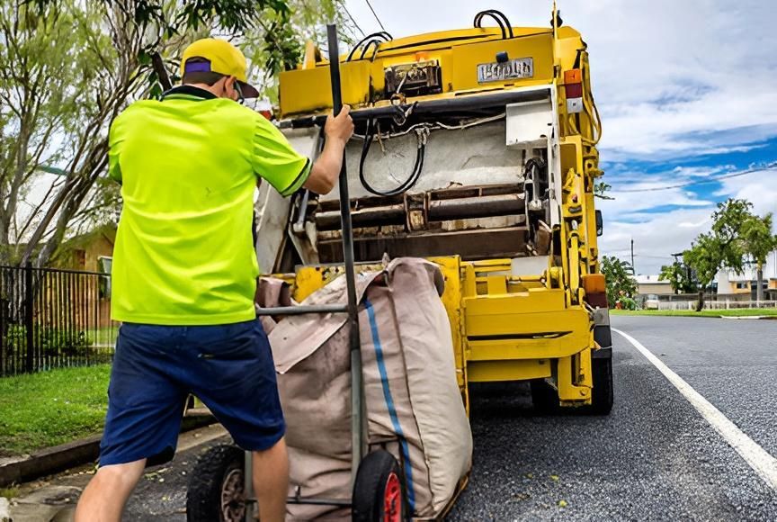 Garbage Collector in Neon Green Shirt and Blue Shorts Pushing a Cart — Bobs Bags & Bins in Mackay, QLD