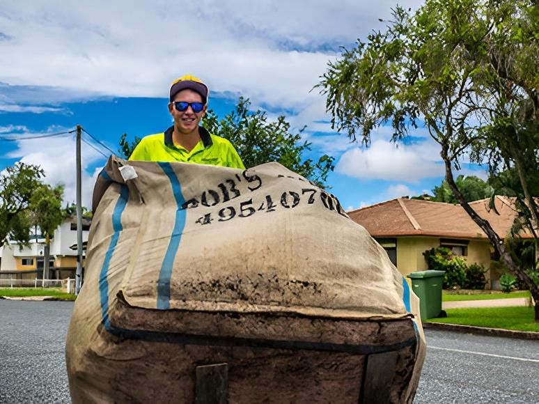 Man With Cap and Sunglasses, Holding Large Worn Bag — Bobs Bags & Bins in Mackay, QLD