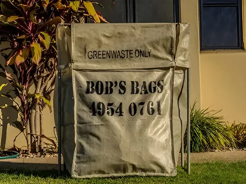 A green waste collection bag on a metal frame with text 