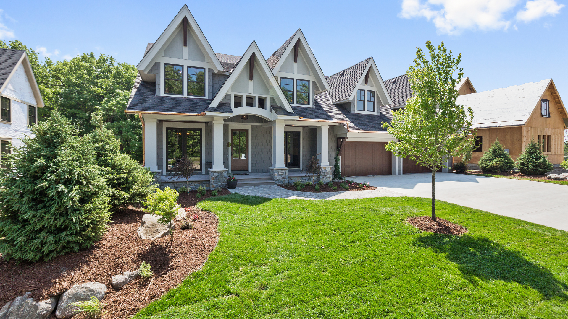 A large white house with a lush green lawn in front of it.