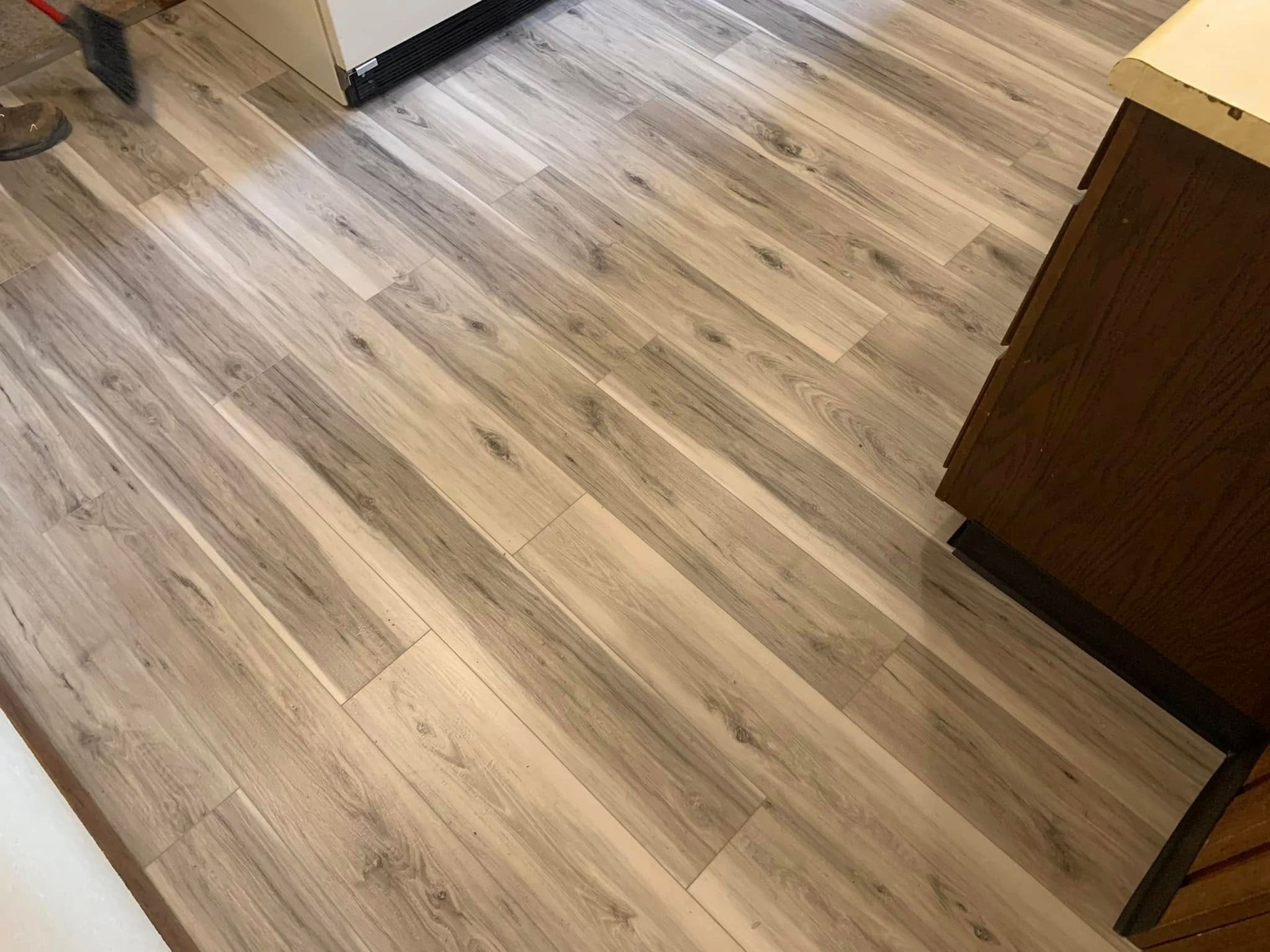 A close up of a wooden floor in a kitchen.