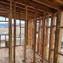 A wooden frame of a house under construction with a lot of windows.