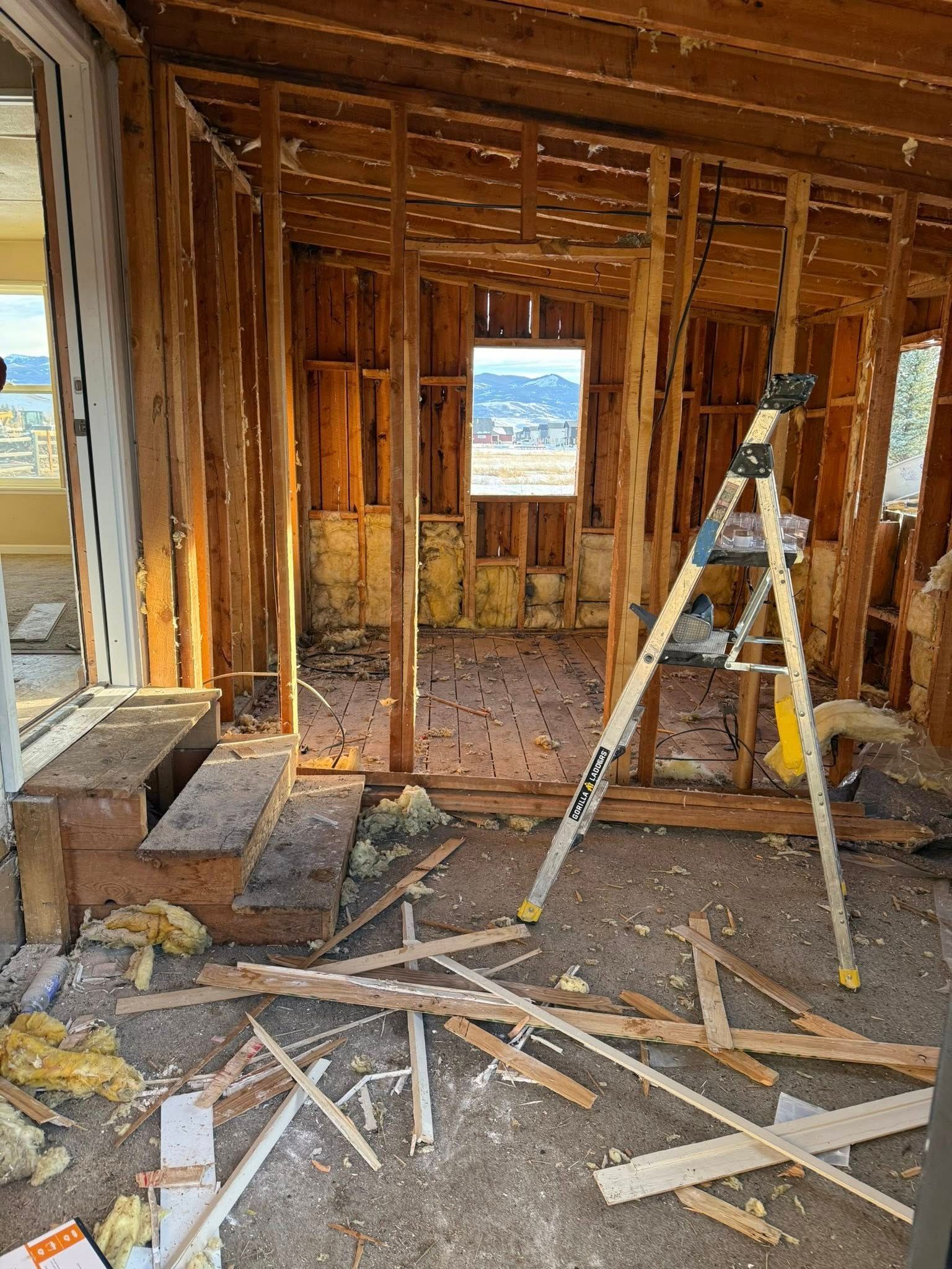 A ladder is sitting in the middle of a room that is being remodeled.