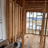 A person is working on a wooden frame of a house.