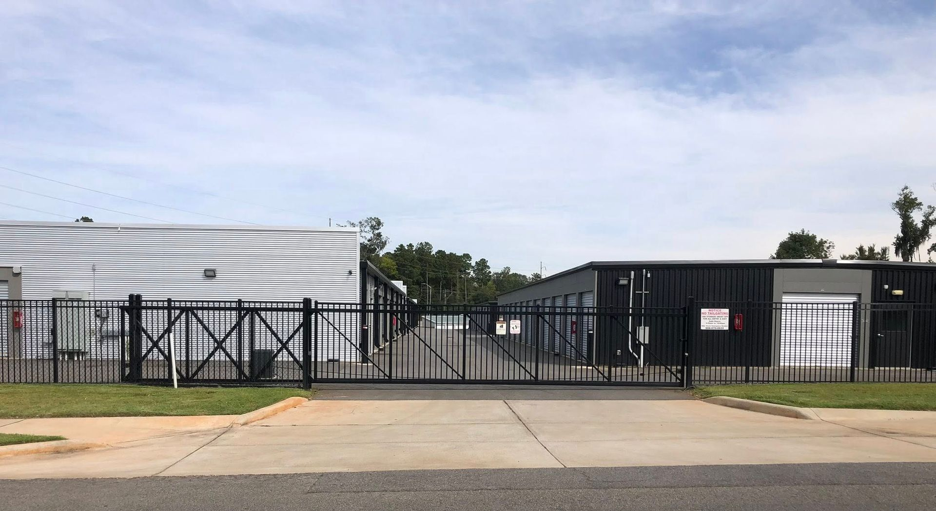 Brown metal vertical bar fence along green grass. Brown metal vertical bar fence along green grass.