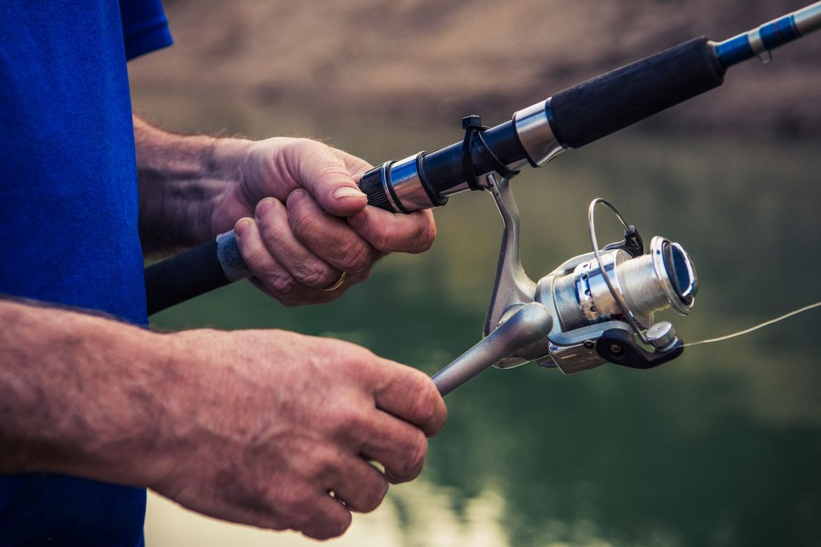 Black wrought iron gate with decorative finials between stone pillars on a paved path. Black wrought iron gate with decorative finials between stone pillars on a paved path.