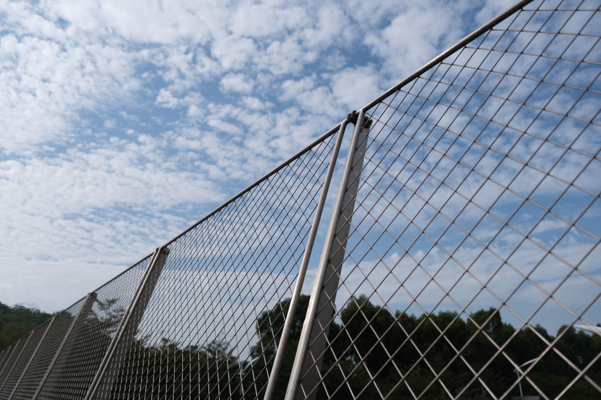 Dark, horizontally ridged metal wall with vertical white supports, angled perspective. Dark, horizontally ridged metal wall with vertical white supports, angled perspective.