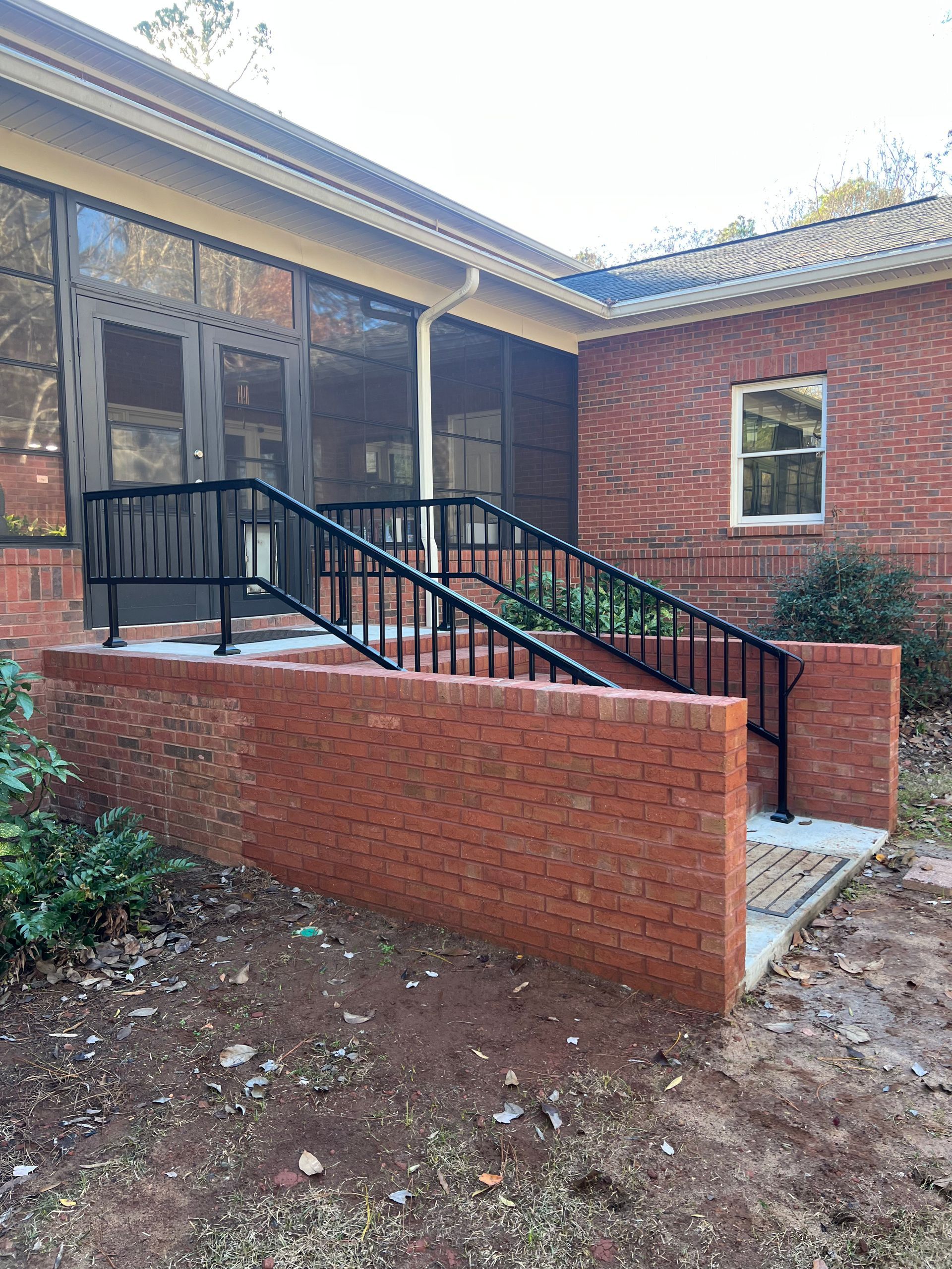 Black and white photo of a staircase with ornate iron railing.